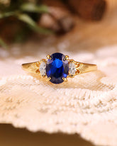LILIOSA Oval Cut Sapphire Three Stone Fleur-de-lis Engagement Ring