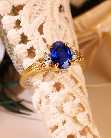 LILIOSA Oval Cut Sapphire Three Stone Fleur-de-lis Engagement Ring