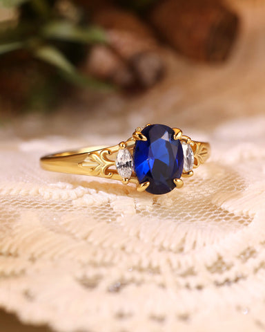 LILIOSA Oval Cut Sapphire Three Stone Fleur-de-lis Engagement Ring